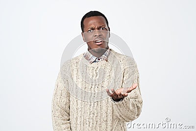 African clueless man, arm out asking who cares so what. Negative human emotion Stock Photo