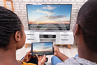 Couple Connecting Television Through Wireless On Tablet Stock Photo