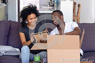 African couple unpacks belongings on moving day at new house Stock Photo