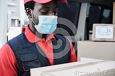 African delivery man wearing face protective mask during coronavirus outbreak - Focus on face Stock Photo