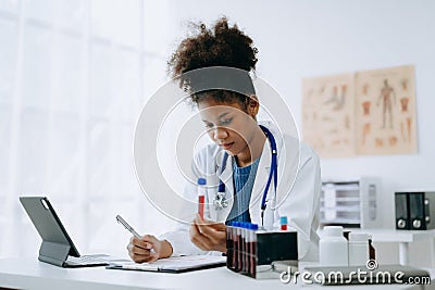 African doctor or consultant sitting at a desk writing sick note, surgery planning and prescription.and clinical report test Stock Photo