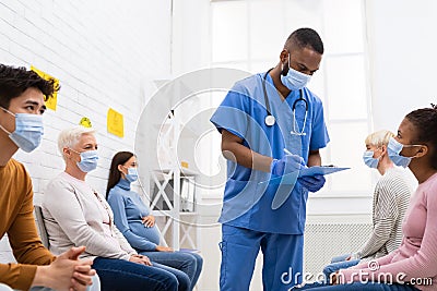 Doctor Working With Diverse Patients In Hospital During Coronavirus Vaccination Stock Photo