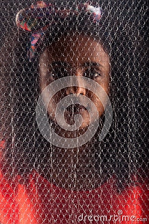 Ethiopian woman behind bubble wrap Stock Photo