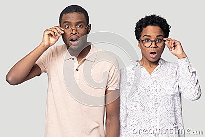 Confused african couple gawp at camera open mouth lowering glasses Stock Photo