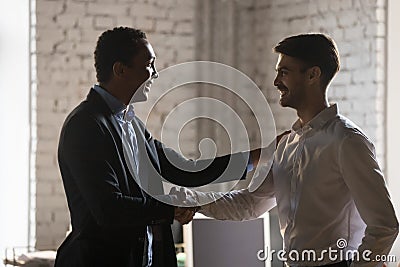 African executive manager handshaking caucasian employee promoti Stock Photo