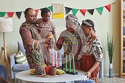 African family of four celebrating Kwanzaa at home Stock Photo