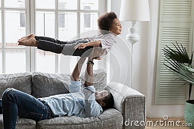 African father lift son, kid imitates plane flying in air Stock Photo