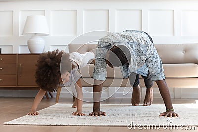 African father and little daughter do push-up exercise indoors Stock Photo