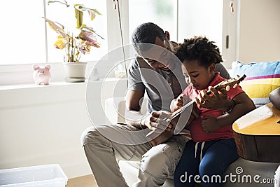 African father teaching son how to play guitar Stock Photo