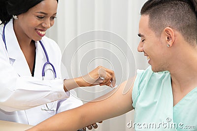 The African female doctor used a cotton swab to wipe the arm of the male patient before the injection Stock Photo