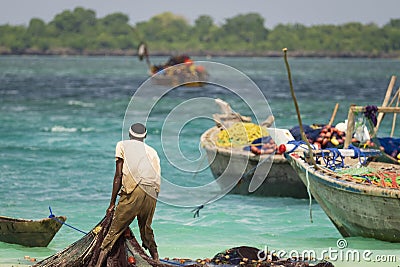 African fisherman catches fishing nets and looks out to sea Editorial Stock Photo