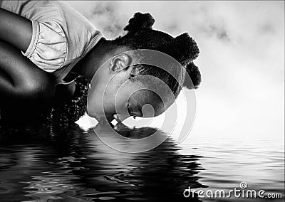 African girl drinking from a river. Stock Photo