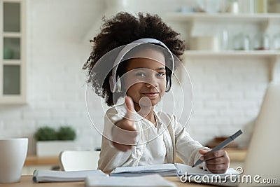African girl in headphones enjoy showing thumbs up e-learning Stock Photo