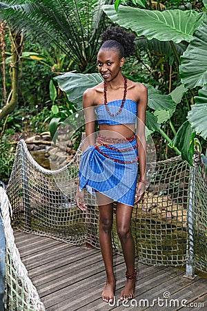 African girl stands on wooden bridge in jungle Stock Photo