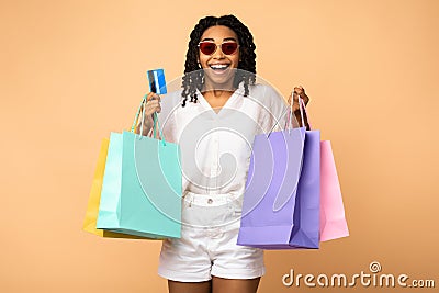 African Girl On Shopping Holding Credit Card, Beige Studio Background Stock Photo