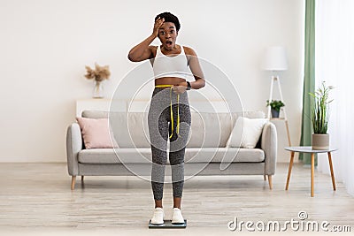 African Lady Weighing After Weight Gain And Measuring Waist Indoors Stock Photo