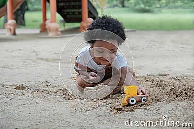 African little boy smile and enjoy playing sand with toys loader on playground outdoors in the park Stock Photo