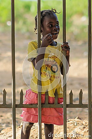 African little girl standing near fence Editorial Stock Photo
