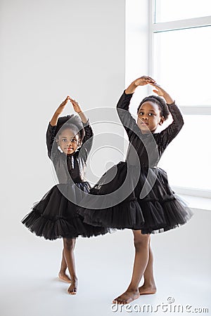 African little ladies in black dress dancing ballet indoors Stock Photo