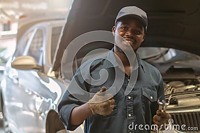 African maintenance male checking car, service via insurance system at automobile repair and check up center Stock Photo