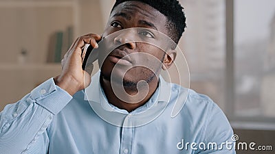 African man businessman american male employee worker answer incoming call talking on phone in home office disappointed Stock Photo
