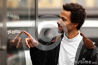 African man buys drink or sweets at vending machine outside Stock Photo
