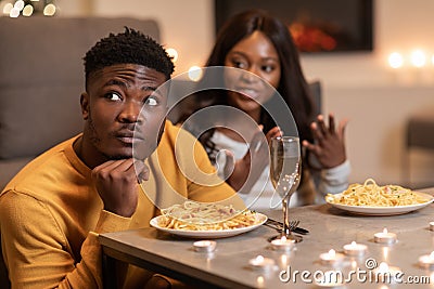 African Man Ignoring Girlfriend During Conversation Celebrating Valentine At Home Stock Photo