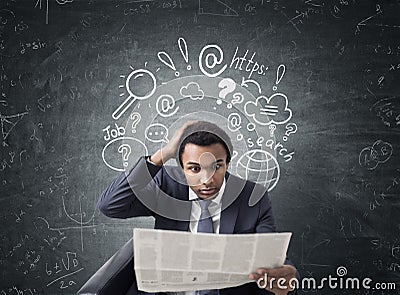 African man with newspaper, internet search Stock Photo