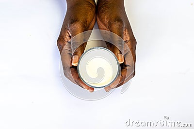 African man`s Hand holding glass of warm fresh milk on white background. Top view food and drink for healthy concept. good calcium Stock Photo