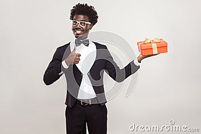 African man thumbs up and holding gift box. Stock Photo