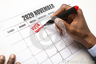 African man writing vote red text on November 2020 calendar Stock Photo