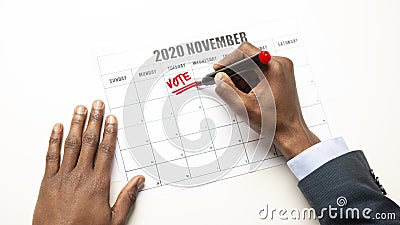 African man writing vote text in Calendar, US General Election Stock Photo