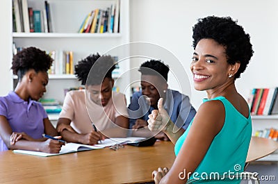 African mature tutor with students at work Stock Photo