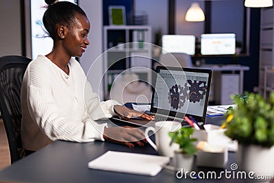 African mechanical designer working on computer late at night Stock Photo