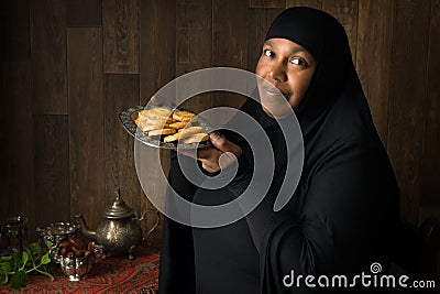 African muslim woman presenting cookies Stock Photo