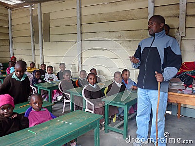 In an African school, a teacher of African ethnicity stands near the blackboard and tells the students a lesson Editorial Stock Photo
