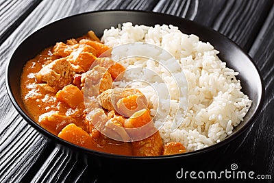 African stew Domoda with peanuts cooked with chicken pumpkin and served with rice close-up in a plate. horizontal Stock Photo