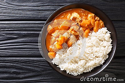 African stew Domoda with peanuts cooked with chicken pumpkin and served with rice close-up in a plate. Horizontal top view Stock Photo
