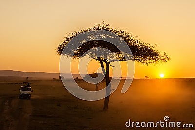 African sunrise with acacia trees and safari car in Masai Mara, Kenya. Savannah background in Africa. Safari concept Stock Photo