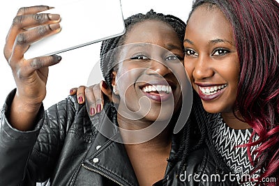 African teen girls taking self portrait with smartphone. Stock Photo