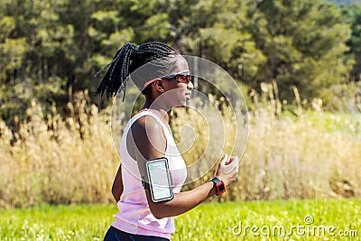 African teen running with fitness activity tracker. Stock Photo