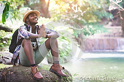 African trekking tourist prays to thank God for the good things in his life. Concept of faith, religion and good life Stock Photo