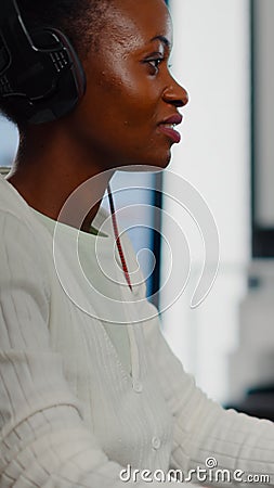 African video editor with headset listening music wihile editing footage Stock Photo