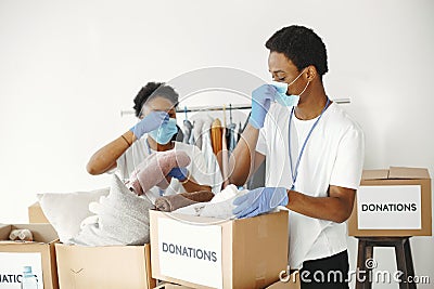 African volunteers in protective masks and gloves pack boxes Stock Photo