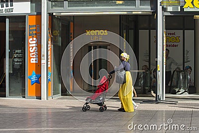 An African woman carrying a baby carriage Editorial Stock Photo