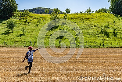 African woman dancing on golden harvested corn field in hot summer afternoon Stock Photo