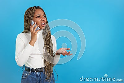 African woman with an expression of incredulity talking with mobile Stock Photo