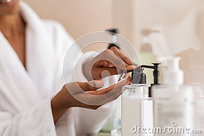 Woman taking body moisturizer from dispenser Stock Photo