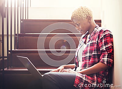 African Woman Searching Internet Sitting on Steps Stock Photo