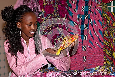 African woman showing yellow beads and fabrics Stock Photo